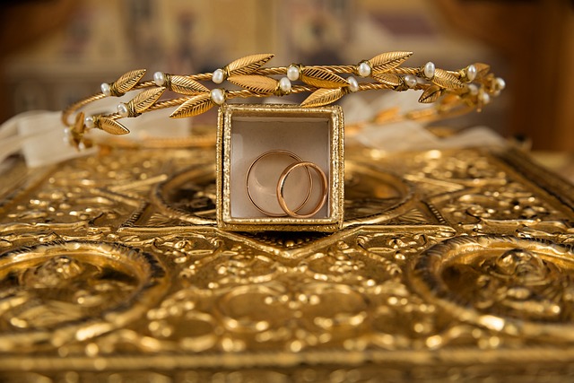 Photo of gold wedding bands in a gold box placed among other golden items.